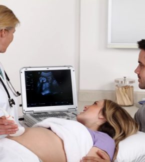 Doctor performing an ultrasound scan for a pregnant woman with her partner.